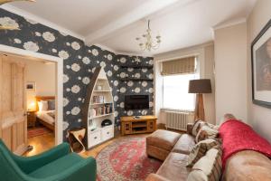 a living room with a couch and a tv at Charming Grassmarket 1 Bed Castle pad in Edinburgh
