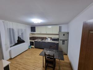 a kitchen with a table and a kitchen with a table and chairs at Casa Sava in Letea Veche