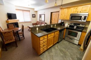 een keuken met een wastafel en een fornuis top oven bij Silverado Lodge - 1 Bedroom Suite with King Bed & Pool View apartment hotel in Park City