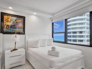 a bedroom with a white bed and a large window at Amazing Ocean View Condo Beach Service 1111 in Miami Beach +41 photos