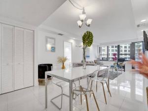 a white dining room with a table and chairs at Amazing Ocean View Condo Beach Service 1111 in Miami Beach