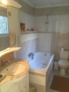 a bathroom with a tub and a sink and a toilet at Les Arches du Cloître in Corneilla-de-Conflent