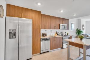 a kitchen with wooden cabinets and a stainless steel refrigerator at Beautiful Unit with Amazing View & Free Parking in Miami