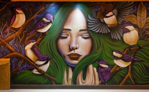 Mural Living Hotel Manaus في ماناوس: لوحة جدارية لامرأة والطيور عليها