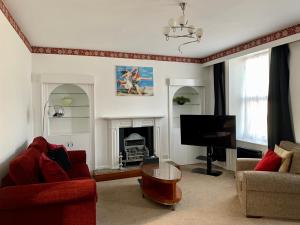 sala de estar con TV y chimenea en Sarum Apart-Hotel en Saint Helier