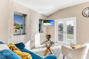 a living room with a blue couch and two windows at Silver Stag Properties, 2 BR Limestone Lodge 