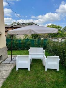 una mesa blanca y dos sillas bajo una sombrilla en Casa San Michele, en Sassuolo