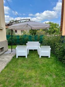 une table blanche et deux chaises sous un parasol dans l'établissement Casa San Michele, à Sassuolo