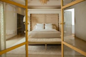 een slaapkamer met een bed met witte lakens en kussens bij Les Palmiers Boutique Hôtel & Spa in Marrakesh