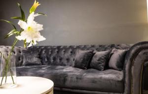 קסם היקינטון סוויטת יוקרה שרדונה في Geva Binyamin: أريكة جلدية سوداء مع وردة بيضاء في مزهرية