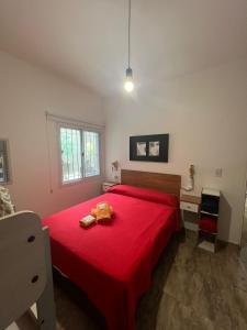 a bedroom with a red bed and a desk at BELLA VISTA Hostel, Aparts & Complejo de Cabañas in Santa Rosa de Calamuchita