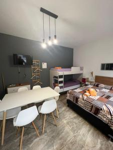 Habitación con cama, mesa y sillas. en BELLA VISTA Hostel, Aparts & Complejo de Cabañas en Santa Rosa de Calamuchita