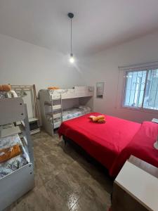 a bedroom with a bed with a red blanket at BELLA VISTA Hostel, Aparts & Complejo de Cabañas in Santa Rosa de Calamuchita