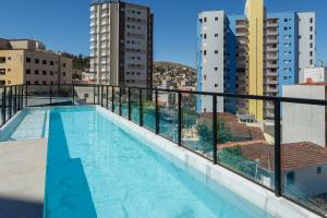 une piscine sur le toit d'un bâtiment dans l'établissement Lindo e aconchegante apto proximo ao centro PGO309, à Poços de Caldas
