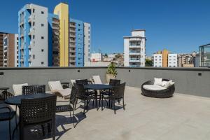 a patio with tables and chairs on a balcony at Lindo e aconchegante apto proximo ao centro PGO309 in Poços de Caldas