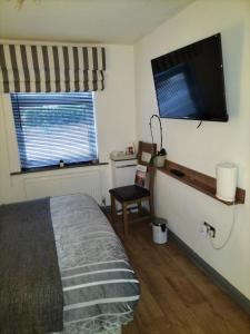 a bedroom with a bed and a flat screen tv at THE NEW INN Newton Derbyshire in Tibshelf