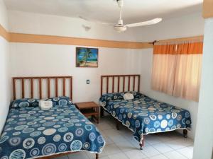 - une chambre avec 2 lits et une fenêtre dans l'établissement Hotel QP, à Chachalacas