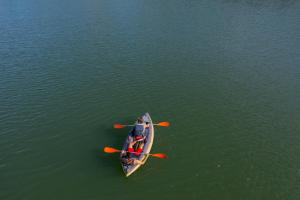 an overhead view of a person in a canoe in the water at Glamping Montecarlo Lodge Cubo de Madera-Guatapé in Guatapé