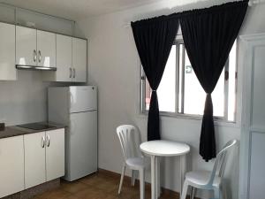 kuchnia ze stołem i krzesłami oraz oknem w obiekcie Apartamentos Playamar II w mieście Valle Gran Rey
