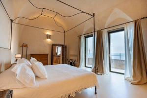 a bedroom with a large bed with a large window at Aurora apartment in Alma Domus in Amalfi