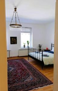- une chambre avec un lit, un tapis et un lustre dans l'établissement Apartman Nostalgia u Sarajevu, à Sarajevo