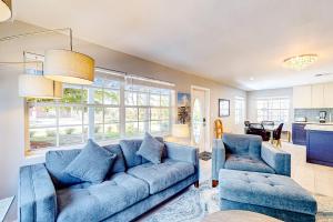 a living room with a blue couch and two chairs at Purple Pelican Cottage in Marco Island