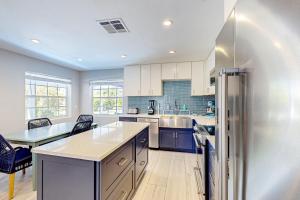 a large kitchen with a refrigerator and a table at Purple Pelican Cottage in Marco Island