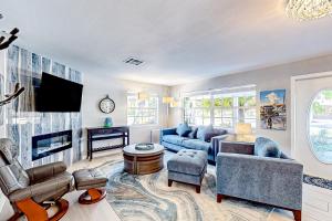 a living room with a couch and a tv at Purple Pelican Cottage in Marco Island