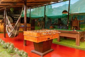 a room with a ping pong table and hammocks at Valle verde, Hostel & camping in Urubamba