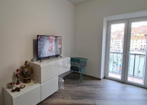 a living room with a tv on a white dresser at Attico vista mare mozzafiato in Porto Santo Stefano