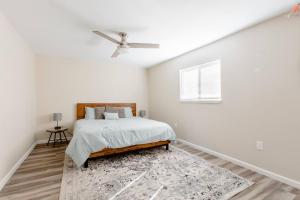 een witte slaapkamer met een bed en een plafondventilator bij Beautiful spacious guest home in Roseville