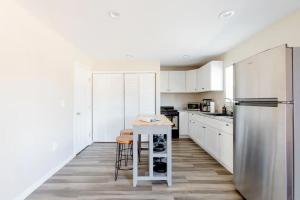 een keuken met witte kasten en een roestvrijstalen koelkast bij Beautiful spacious guest home in Roseville