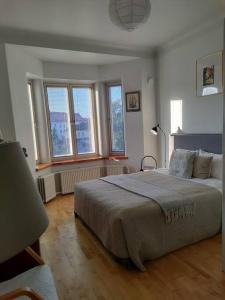 a bedroom with a large bed and some windows at Top-floor studio, near park & sea, great transit in Helsinki
