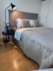 1 dormitorio con 1 cama y 1 mesa con lámpara en Top-floor studio, near park & sea, great transit en Helsinki