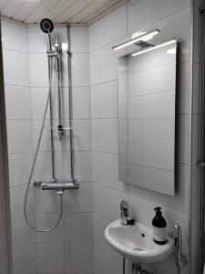 Baño blanco con lavabo y espejo en Top-floor studio, near park & sea, great transit, en Helsinki