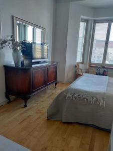 1 dormitorio con 1 cama y vestidor con TV en Top-floor studio, near park & sea, great transit en Helsinki