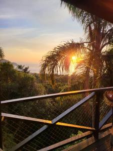 uma vista para o pôr-do-sol a partir do deque de uma casa em La Roca House na Praia do Rosa