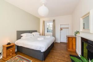 una camera con un grande letto e un camino di Stunning Stables Cottage in East Lothian Country Estate a North Berwick