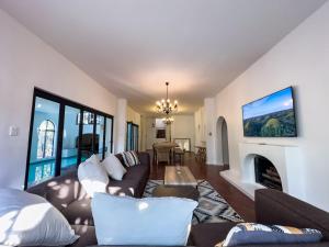 a living room with a couch and a fireplace at Riverside House with Indoor Pool in Johannesburg