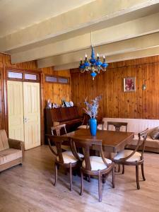 uma sala de jantar com uma mesa e cadeiras e um lustre em anno's house em Zugdidi