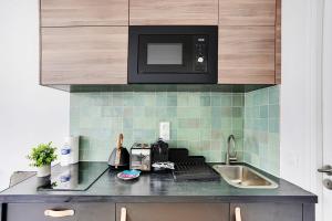 a kitchen with a sink and a microwave at Amazing studio 2P - République in Paris