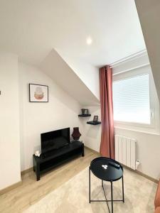 a living room with a television and a chair at /Sacré studio/Parking privé/Wifi in Rodez
