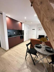 a living room with a table and a kitchen at /Sacré studio/Parking privé/Wifi in Rodez