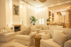 a living room with white furniture and a fireplace at Les Palmiers Boutique Hôtel & Spa in Marrakech