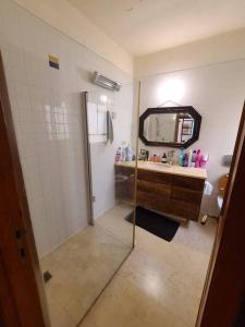 ein Bad mit einer Dusche, einem Waschbecken und einem Spiegel in der Unterkunft gorgeous herzeliya pool villa in Herzlia
