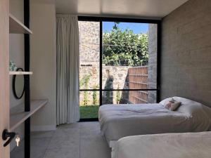 - une chambre avec 2 lits et une grande fenêtre dans l'établissement Casa del ALMA., à Tepoztlán
