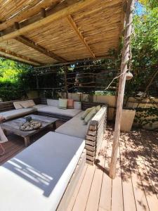 um pátio com um sofá e uma mesa sob um telhado de madeira em gorgeous herzeliya pool villa em Herzelia 