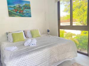a bedroom with a white bed with towels on it at Hacienda Iguana beach front Penthouse with swimming pools and ocean view in Tola