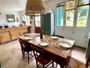 a dining room table with chairs and a bottle of wine at Penty LEGONA, authentique et chaleureux, 2-6 pers in Moëlan-sur-Mer