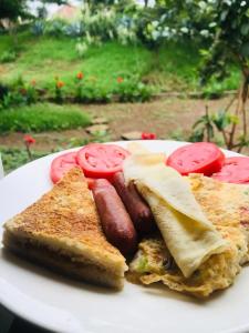 - un plateau de petit-déjeuner composé de saucisses et de tomates dans l'établissement WAWA HOTEL, à Turiani